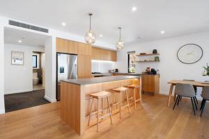 une cuisine avec un comptoir, des tabourets et une table dans l'établissement Lakeside Luxury 2 Bedroom Apartment, à Wanaka 20 autres photos