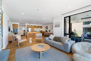 a living room with a couch and a table at Lakeside Luxury 2 Bedroom Apartment in Wanaka