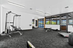 una habitación con un gimnasio con cintas de correr y máquinas en Lakeside Luxury Studio Apartment, en Wanaka