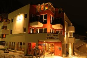 a building with people standing outside of it at night at Hotel Garni & Aparthotel COLLINA in Ischgl