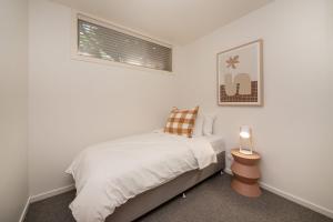 a white bedroom with a bed and a window at Heart of Hampton by the Beach in Melbourne +25 photos