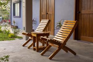 two wooden chairs and a table in front of a house at Casa Morada in Antón