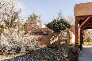 un antiguo edificio con una valla en un patio en Group Getaway: Serene Adobe Retreat 4-11 guests en Albuquerque