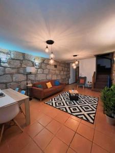 een woonkamer met een bank en een stenen muur bij Invited to Porto in Porto