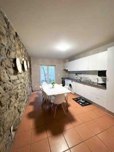 een keuken met een witte tafel en een stenen muur bij Invited to Porto in Porto
