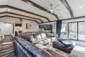 sala de estar con sofá de cuero y mesa en RiverEdge Haven Hot Tub, 5 Beds, Kayaks Near ND, en Niles