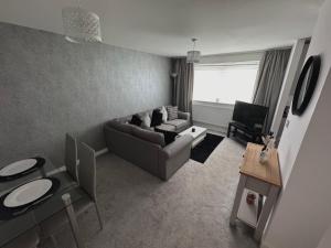 Modern 2 bed city apartment with private parking في سوانسي: غرفة معيشة مع أريكة وكرسي