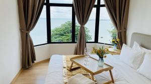Tangga BatuにあるMutiara Melaka Beach Paradise by Glexのベッドルーム1室(ベッド1台、花のテーブル付)
