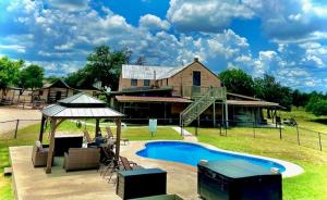 a house with a swimming pool in front of a house at Country Inn Cottages in Fredericksburg