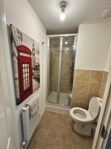bagno con servizi igienici e cabina telefonica rossa. di Modern 2 bed city apartment with private parking a Swansea