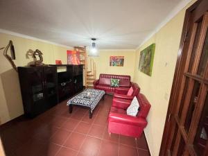 un soggiorno con divano rosso e tavolo di Cosy Home Near Serra da Estrela a Gouveia