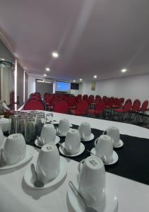 una sala de conferencias con tazas blancas y platillos sobre una mesa en Hotel Rarinco, en Los Ángeles