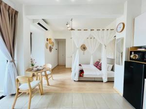 a bedroom with a white bed and a table and chairs at Mutiara Melaka Beach Paradise by Glex in Tangga Batu