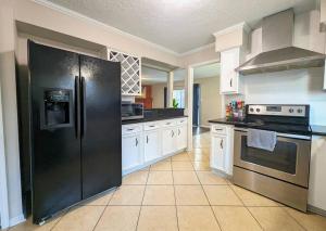 eine große Küche mit einem großen schwarzen Kühlschrank in der Unterkunft Quiet, Spacious, Pet-Friendly in Humble + 25 Fotos
