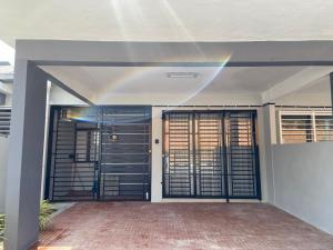 a house with two garage doors with a rainbow at Damai Homestay Kuala Krai in Kuala Kerai