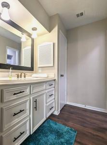a white bathroom with a sink and a mirror at Quiet, Spacious, Pet-Friendly in Humble