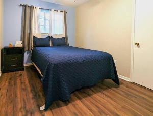 Un dormitorio con una cama azul y una ventana en Quiet, Spacious, Pet-Friendly en Humble