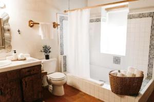 Group Getaway: Serene Adobe Retreat 4-11 guests في ألباكيركي: حمام مع مرحاض وحوض استحمام ومغسلة