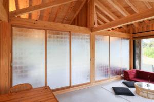 Habitación con techos de madera y ventanas de cristal. en 泊まれるアートミュージアム 琉球ヴィラ en Tatsugo