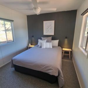 1 dormitorio con 1 cama grande y 2 ventanas en Pichi Richi Park, en Quorn