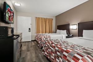 um quarto de hotel com duas camas e uma televisão em Red Roof Inn Spartanburg - I-85 em Spartanburg