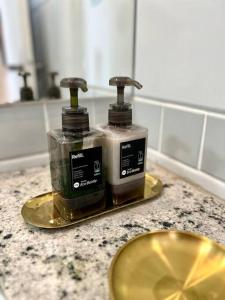 two bottles ofodorizers sitting on a counter in a bathroom at Oásis Urbano com Netflix na Raja Gabáglia in Belo Horizonte