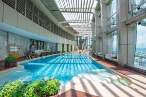 a large swimming pool in a building with windows at Hyatt Place Sanya City Center in Sanya