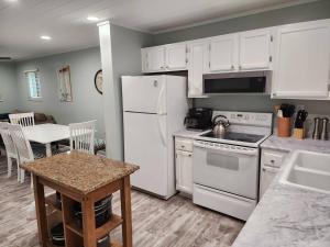a kitchen with white appliances and a table with chairs at Tranquility By The Beach 1st Fl Sleeps 6,king Bed in Hilton Head Island