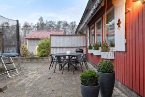 a patio with a table and chairs on the side of a house at Radhus med 5 min bilavstånd till centrum & strand in Halmstad