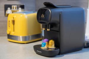 uma máquina de café sentada ao lado de um espremedor amarelo em Guild Street Apartment ✪ Grampian Lettings Ltd em Aberdeen