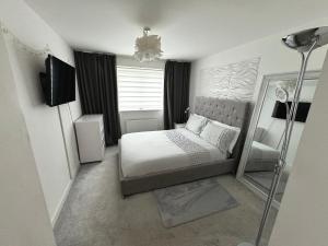 a small bedroom with a bed and a mirror at Modern 2 bed city apartment with private parking in Swansea