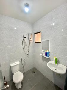 a bathroom with a shower and a toilet and a sink at Damai Homestay Kuala Krai in Kuala Kerai