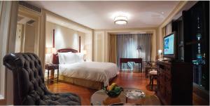 une chambre d'hôtel avec un lit et un salon dans l'établissement Sunrise On The Bund, à Shanghai