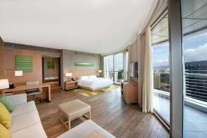 a hotel room with a bed and a large window at Hyatt Place Sanya City Center in Sanya