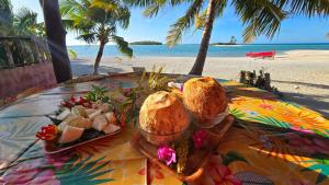 una mesa con pan y un plato de comida en la playa en Tikehau HereArii Airbnb, en Tikehau