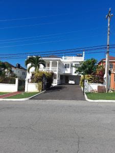 een groot wit huis met een oprit ervoor bij Montego Bay westgate Hills jamaica Melrose place in Montego Bay