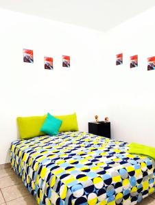ein Schlafzimmer mit einem gelben und blauen Bett in der Unterkunft MI HOGAR in Tegucigalpa