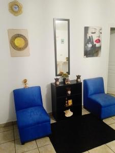 Zimmer mit 2 blauen Stühlen und einem Spiegel in der Unterkunft MI HOGAR in Tegucigalpa