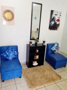 Zimmer mit 2 blauen Stühlen und einem Spiegel in der Unterkunft MI HOGAR in Tegucigalpa