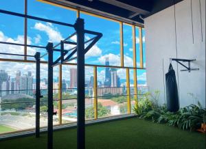 a gym with a large window with a view of the city at Opus Signatures ChinaTown 118 in Kuala Lumpur