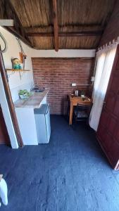 - une cuisine avec un évier et un bureau dans la chambre dans l'établissement CABAÑA B COMPLEJO AIRES SERRANOS 2 a 3 PERSONAS TANTI, à Córdoba