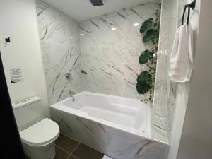 bagno con vasca bianca e servizi igienici di Bramasole Hotel Boutique - El Peñol a El Peñol
