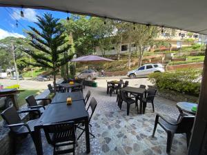 un grupo de mesas y sillas en un patio en Bramasole Hotel Boutique - El Peñol en El Peñol