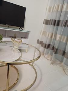 - un salon avec une table en verre et une télévision dans l'établissement Bello Apartamento, 2 habitaciones 2 baños Santo Domingo Carmen Renata III, à Saint-Domingue