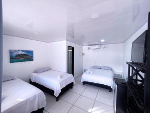 Habitación de hotel con 2 camas y TV de pantalla plana. en Island Vibes, en San Andrés