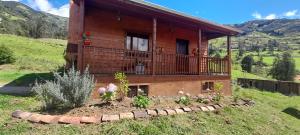 a house with a balcony on a hill at Rancho Valle del Rio in Cuenca