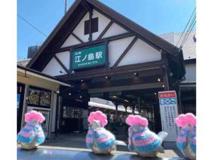 um grupo de três bichos de pelúcia sentados em frente a um edifício em KAMEYA HOUSE ENOSHIMA - Vacation STAY 69765v em Fujisawa