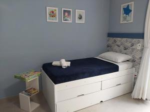 a bedroom with a bed with a blue wall at Minha Casinha Azul na Represa in Paranapanema