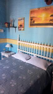 1 dormitorio con 1 cama con pared azul en POSADA DEL PESCADOR en Goya