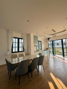 a dining room with a table and chairs at Novaworld Phan Thiết The Blue Villa in Bình Tú